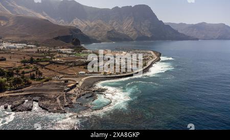 Blick aus der Vogelperspektive auf die Stadt Agaete im Norden der Insel Gran Canaria, mit natürlichen Pools am Meer und dem Tamadaba-Massiv im Backgr Stockfoto