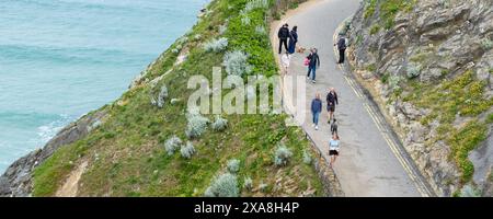 Ein Panoramablick von Urlaubern Besucher, die entlang der Zufahrt zum GT Western Beach in Newquay in Cornwall in Großbritannien spazieren. Stockfoto