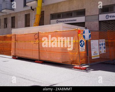 Cremona, Italien – Baustelle am 27. Mai 2024, mit orangefarbenen Sicherheitsnetzen und Schildern gesichert, die auf laufende Arbeiten und potenzielle Gefahren hinweisen. Pede Stockfoto