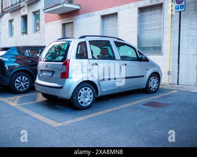 Cremona, Italien - 27. Mai 2024 ein silberner Wagen mit einer Delle in der hinteren Seitentür steht auf einem Parkplatz. Das Auto steht neben einem blauen behinderten Vater Stockfoto