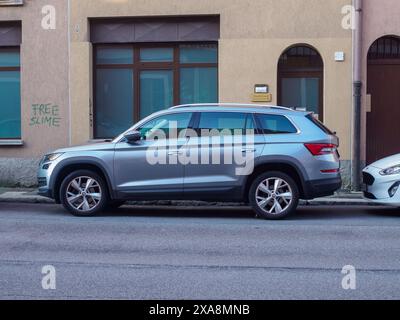 Cremona, Italien - 27. Mai 2024 der Skoda Konjac Silver suv parkt auf einer schmalen Straße vor einem Gebäude, mit einem kostenlosen Schleim-Graffiti an der Wand BE Stockfoto