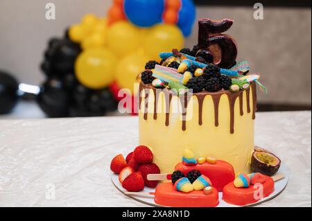 Festlich dekorierter Kuchen zum Geburtstag eines Kindes mit fünf Jahren auf dem Tisch Stockfoto