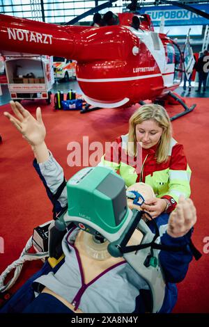 Dortmund, Deutschland. Juni 2024. Jaqueline Baltrusch, Rettungssanitäterin, sieht auf der Fachmesse „112Rescue“ eine Schaufensterpuppe mit einer Wiederbelebungshilfe für Herzmassagen. Die viertägige Fachmesse richtet sich an Einzelpersonen, Vereine, Verbände und Organisationen aus den Bereichen Brandschutz, Rettung, Katastrophenschutz und Katastrophenschutz. Quelle: Bernd Thissen/dpa/Alamy Live News Stockfoto