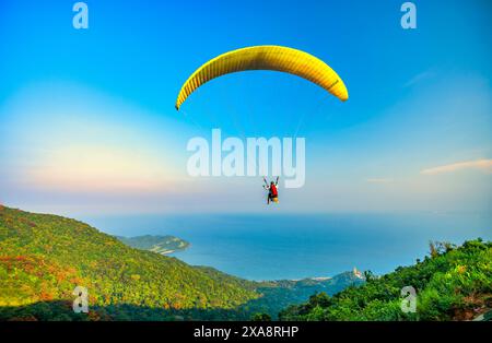 Die Paragliding-Tour beginnt am Gipfel des Son Tra Berges und landet am da Nang Strand für Touristen, die den Nervenkitzel in da Nang, Vietnam, erkunden möchten Stockfoto