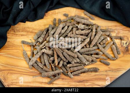 Langer Pfeffer (Piper longum), auf einem Holzbrett Stockfoto