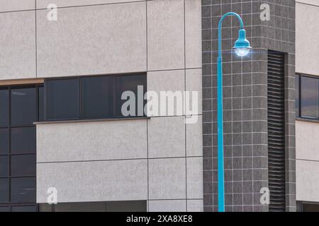 Generisches Geschäftsgebäude mit blauer Straßenlaterne im Vordergrund Stockfoto