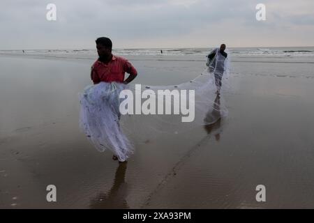 5. Juni 2024, Cox's Bazar, Chittagong, Bangladesch: Fischer fangen Fische mit Fischernetzen am Cox's Bazar Sea Beach, Bangladesch. Der Lebensunterhalt der Fischer hängt hier weitgehend von der Fischerei ab. Cox's Bazar, der längste natürliche Meeresstrand der Welt, erstreckt sich über 120 km entlang der Südostküste Bangladeschs. Berühmt für seinen goldenen Sand, die pulsierenden Sonnenuntergänge und die sanfte Brandung, zieht es jährlich Millionen von Touristen an. (Kreditbild: © Joy Saha/ZUMA Press Wire) NUR REDAKTIONELLE VERWENDUNG! Nicht für kommerzielle ZWECKE! Stockfoto