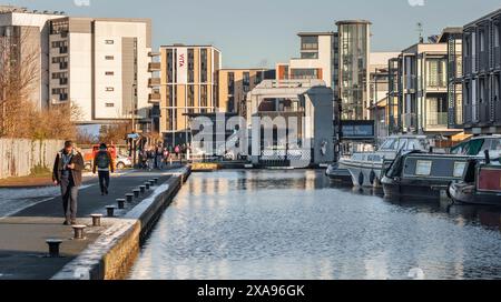 Edinburgh, Schottland; 01-30-2019: Menschen, die entlang des Union Canal in der Nähe der Fountainbridge spazieren, mit der alten Leamington Lift Bridge im Hintergrund. Winter Stockfoto