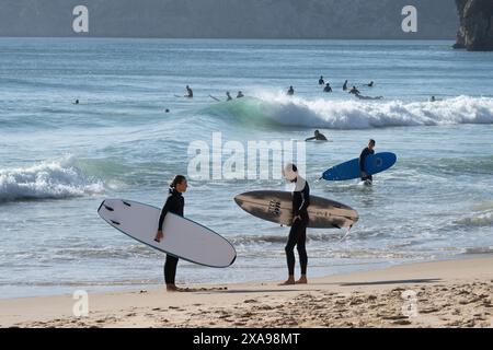 Surfer mit Surfbrettern an der Strandküste von Sagres an der äußersten Westspitze der Algarve, Faro, Portugal Stockfoto