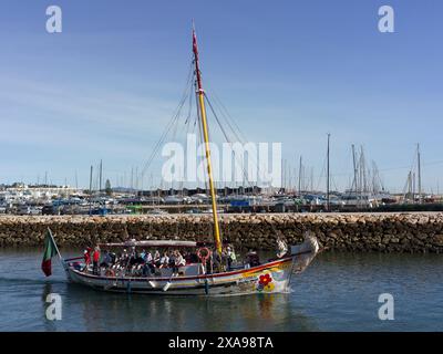 Segelboot mit Passagieren im Hafen von Lagos in der südportugiesischen Algarve, bekannt für ihre ummauerte Altstadt, Klippen und Atlantikstrände Stockfoto