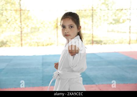 Ein Mädchen in Kimono, das draußen Karate auf Tatami übt Stockfoto