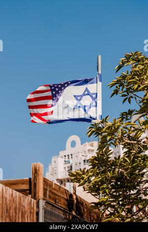 Die israelische amerikanische Freundschaftsflagge schmeichelt im Wind. Hybridflagge als Symbol der vereinigung zwischen Israel und den USA Stockfoto