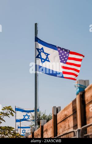 Die israelische amerikanische Freundschaftsflagge schmeichelt im Wind. Hybridflagge als Symbol der vereinigung zwischen Israel und den USA Stockfoto