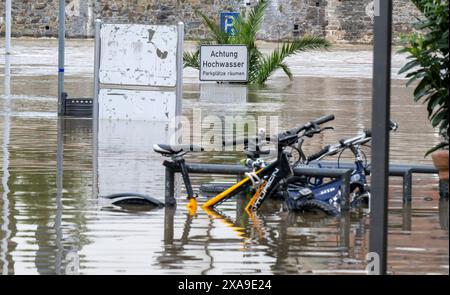 Passau, Deutschland. Juni 2024. Am überfluteten Ufer der Dreiflüssestadt steht ein Schild mit der Aufschrift „Achtung Hochwasser“. Nach starken Regenfällen sind viele Orte in Bayern weiterhin überflutet. Quelle: Peter Kneffel/dpa/Alamy Live News Stockfoto