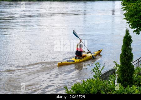 Passau, Deutschland. Juni 2024. Ein Mann paddelt am Ufer des Gasthauses in einem Kajak im Hochwasser entlang. Nach starken Regenfällen sind viele Orte in Bayern weiterhin überflutet. Quelle: Peter Kneffel/dpa/Alamy Live News Stockfoto