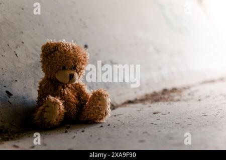 Obdachloser einsamer armer Teddybär, der in einem dunklen Tunnel unter der Brücke sitzt. Obdachlosigkeit, Armut, Depression, Drogenabhängigkeit Konzeptbild Stockfoto