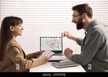 Kartografen arbeiten mit Katasterkarten am Computer am Tisch im Büro Stockfoto