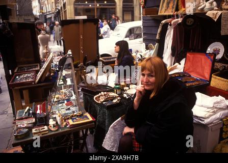 Straßenmärkte London. Golborne Road, nördliches Ende der Portobello Road. Samstag traditioneller Antiquitätenmarkt und Backsteinmarkt. Frau Markthalter. 1990s UK 1999. Die Golborne Road war der Ort, an dem ein Großteil des Films Notting Hill gedreht wurde. Stockfoto