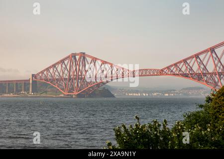 Ein Zug überquert die berühmte Forth Bridge. Die 1890 fertiggestellte Freischwinger-Eisenbahnbrücke überspannt den Firth of Forth westlich des Zentrums von Edinburgh. Stockfoto