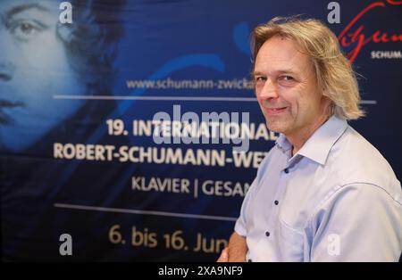 05. Juni 2024, Sachsen, Zwickau: Thomas Synofzik, Direktor des Robert-Schumann-Hauses und Vorsitzender der Jury des Internationalen Robert-Schumann-Wettbewerbs für Klavier und Gesang, steht vor einem Logo der Veranstaltung. In den nächsten zehn Tagen werden 66 junge Pianisten und 79 Sängerinnen und Sänger erwartet, darunter auch einige aus Asien und Amerika. Die Stadt Zwickau, in der der Komponist Robert Schumann geboren wurde, veranstaltet alle vier Jahre den nach ihm benannten Musikwettbewerb. Dieses Jahr findet sie vom 6. Bis 16. Juni zum 19. Mal statt. Die Preise für die besten Virtuosen werden mit bis zu 10.000 Preisen bestückt Stockfoto