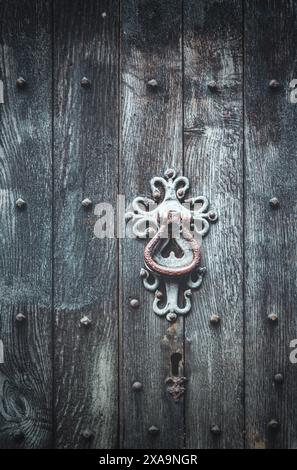 Nahaufnahme eines komplizierten Metallriegels an einer Holztür Stockfoto
