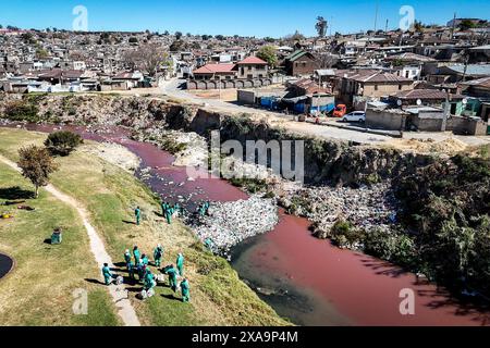 Johannesburg. Juni 2024. Ein Foto der Luftdrohne, das am 5. Juni 2024 aufgenommen wurde, zeigt Arbeiter, die den Jukskei River in Alexandra, Johannesburg, Südafrika, säubern. Johannesburg führte anlässlich des Weltumwelttages eine Aufräumkampagne durch, um das Bewusstsein für die biologische Vielfalt und den Umweltschutz zu schärfen. Quelle: Shiraaz Mohamed/Xinhua/Alamy Live News Stockfoto