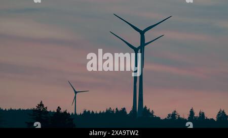 Ein malerischer Blick auf Windturbinen auf dem Hügel bei Sonnenuntergang Stockfoto