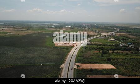 Phnom Penh. Juni 2024. Ein am 4. Juni 2024 aufgenommenes Luftdrohnenfoto zeigt einen Teil der dritten Ringstraße im südlichen Vorort Phnom Penh, Kambodscha. Die von China finanzierte dritte Ringstraße erstreckt sich vom Highway 1 bis zum Highway 4 und hat den einst ruhigen südlichen Vorort Phnom Penh, der Hauptstadt Kambodschas, in ein geschäftiges Vorstadtgebiet verwandelt. UM ZU „Feature: China-finanzierte Ringstraße fördert Entwicklung im südlichen Teil der kambodschanischen Hauptstadt“ Credit: Van POV/Xinhua/Alamy Live News Stockfoto