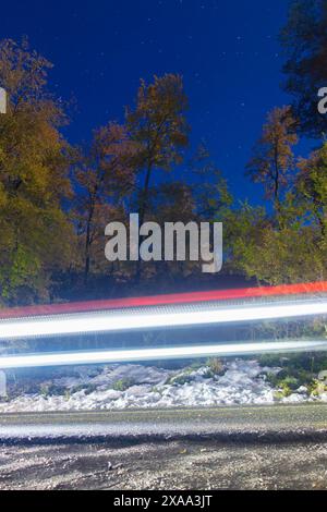 Eine geschäftige Stadtstraße bei Nacht mit Streifen beweglicher Lichter Stockfoto
