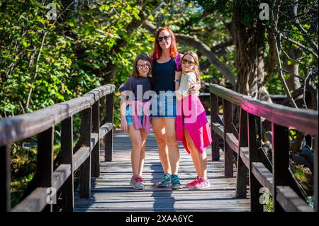 Familienwanderung auf Holzbrücken der Krka-Wasserfälle. Mutter und Töchter spazieren über den hölzernen Brückenweg auf dem Fluss Krka und Wasserfällen in Kroatien. Stockfoto
