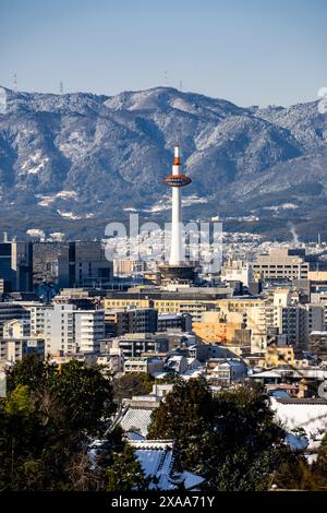 Der Blick auf den Nidec Kyoto Tower mit der Skyline der Stadt und den Bergen im Hintergrund. Kyoto, Japan Stockfoto