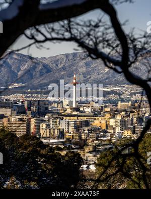 Der Blick auf den Nidec Kyoto Tower mit der Skyline der Stadt und den Bergen im Hintergrund. Kyoto, Japan Stockfoto