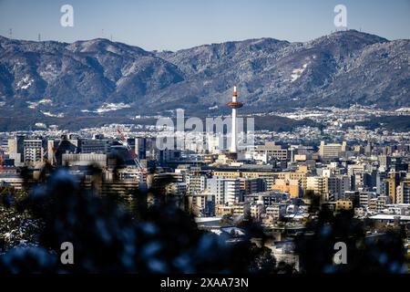 Der Blick auf den Nidec Kyoto Tower mit der Skyline der Stadt und den Bergen im Hintergrund. Kyoto, Japan Stockfoto