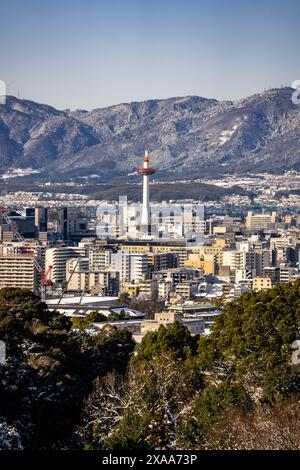 Der Blick auf den Nidec Kyoto Tower mit der Skyline der Stadt und den Bergen im Hintergrund. Kyoto, Japan Stockfoto