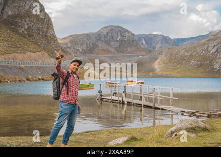 Ein Mann steht auf einer Brücke mit Blick auf eine Lagune sieben Farben, Straße zum Gebirge der Viuda, Canta. Peru. Stockfoto