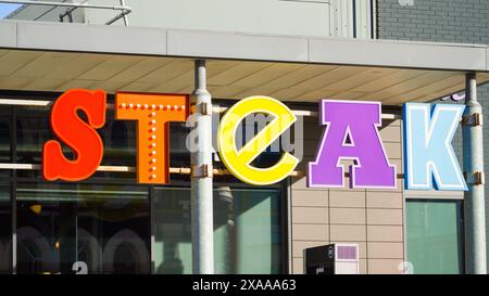 Cardiff, Wales 29. Oktober 2023: Stadtlandschaft, Zeichen und Symbole im Zentrum von Cardiff. Ein riesiges farbenfrohes Schild mit der Aufschrift Steak vor einem Restaurant. Stockfoto