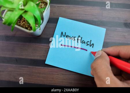 Das Konzept des Newsflash-Schreibens auf Haftnotizen isoliert auf Holztisch. Stockfoto