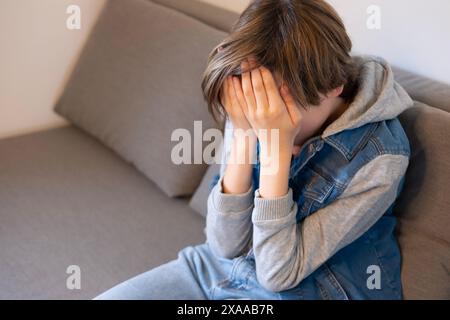 Müdes, krankes Teenager-Kind, das sich mit akademischem Druck und persönlichem Wachstum auseinandersetzt, Trost sucht in einem Moment stille Reflexion, Kindheitsstress Stockfoto