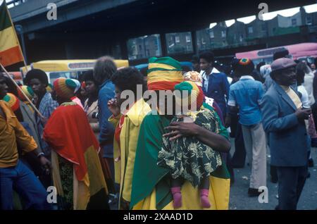 Rastafarier Mutter und Kind in den äthiopischen Farben; rot, grün und gelb. Notting Hill Karneval August Bankfeiertag Montag 1979. London, England 1970er Jahre, Großbritannien HOMER SYKES Stockfoto