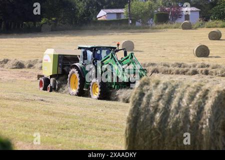 Limousin, Frankreich. Juni 2024. Heuerzeugung in Limousin. Nach den langen Frühlingsregnern ist es an der Zeit, Heu im Südwesten Frankreichs zu ernten. Dieses von den Limousin-Landwirten geerntete Heu wird im Winter zur Fütterung von Limousin-Rindern verwendet. Landwirtschaft, Landwirte, Viehzüchter, Viehzucht, landwirtschaftliche Arbeit, Essen. Limousin, Nouvelle Aquitaine, Frankreich. Europa. Foto: Hugo Martin/Alamy Live News. Stockfoto