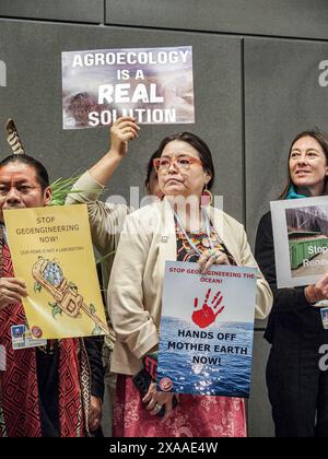 Bonn, Deutschland. Juni 2024. Eine Frau hält ein Schild Hände von Mutter Erde, in einer Reihe von Personen, die an einer Demonstration zum Klimawandel im World Conference Center auf dem UN-Campus in Bonn während der ersten Woche der SB60-Konferenz zum Klimawandel beteiligt waren. Die Finanzierung fossiler Brennstoffe und die Forstwirtschaft stehen im Mittelpunkt der Diskussionen und Verhandlungen. Dies ist die Vorbereitung der COP29-Veranstaltung, die im November dieses Jahres in Baku, Aserbaidschan, stattfinden wird. (Kreditbild: © Bianca Otero/ZUMA Press Wire) NUR REDAKTIONELLE VERWENDUNG! Nicht für kommerzielle ZWECKE! Stockfoto