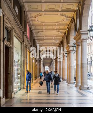 Turin, Italien - 15. Oktober 2019: Menschen schlendern unter den Lauben der Altstadt an einem regnerischen Tag (Via Roma). Stockfoto