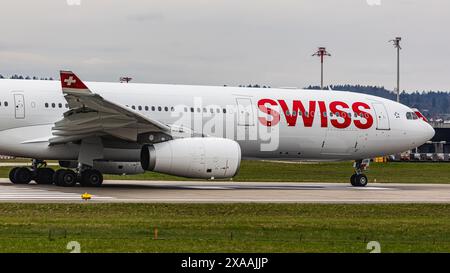 Ein Swiss International Airlines Airbus A330-343X fährt mit dem Taxi auf die Start- und Landebahn am Flughafen Zürich, wo er auf die Freigabe wartet. Registrierung H Stockfoto