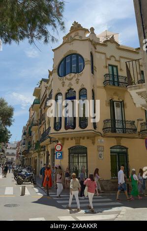 Sitges, Barcelona, Spanien-05. Juni 2024: Das Haus Manel Planas in Sitges zeigt an einem sonnigen Tag mit Menschen seine modernistische Fassade und sein großes ovales Fenster Stockfoto