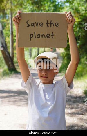 Kind in der Natur mit Poster RETTET DEN PLANETEN Stockfoto