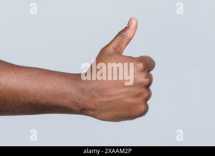 Wie eine Geste. Nahhand mit Daumen nach oben. Mannhände zeigen Daumen hoch. Unterstützen Sie ermutigen. Afrikanische männliche Hand mit Daumen nach oben. afroamerikaner Stockfoto