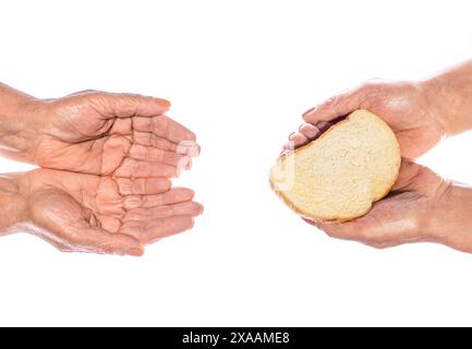 Hand mit einer Scheibe Vollkornbrot. Hilfe für Obdachlose. Frau gibt armen Obdachlosen Brotstücke, Spenden, Nahaufnahme. Die Hand der alten Frau Stockfoto