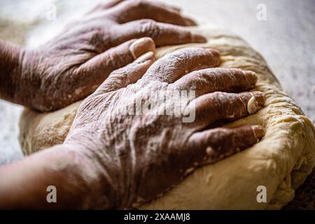 Teig vorbereiten. Die Vorbereitung macht die Hände von Frauen dünn. Teig mit männlichen Händen in der Bäckerei herstellen. Speisekonzept. Hände-Teig. Weibliche Hände, für die Teig gemacht wird Stockfoto