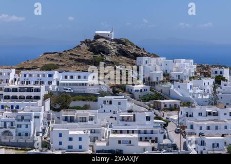 IOS, Griechenland - 4. Mai 2024 : Blick auf verschiedene weiß getünchte Hotels, eine Kirche auf dem Hügel und die Ägäis im Hintergrund in iOS Griechenland Stockfoto