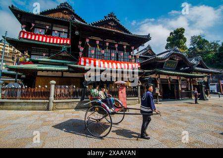 Japanische Rikscha vor dem Dogo Onsen Old Spa, Matsuyama, Shikoku, Japan, Asien Stockfoto